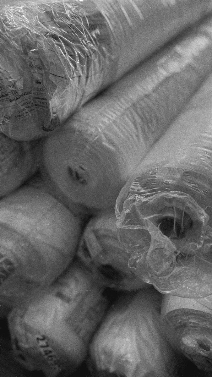 Rolos de tecido no ateliê, em preto e branco